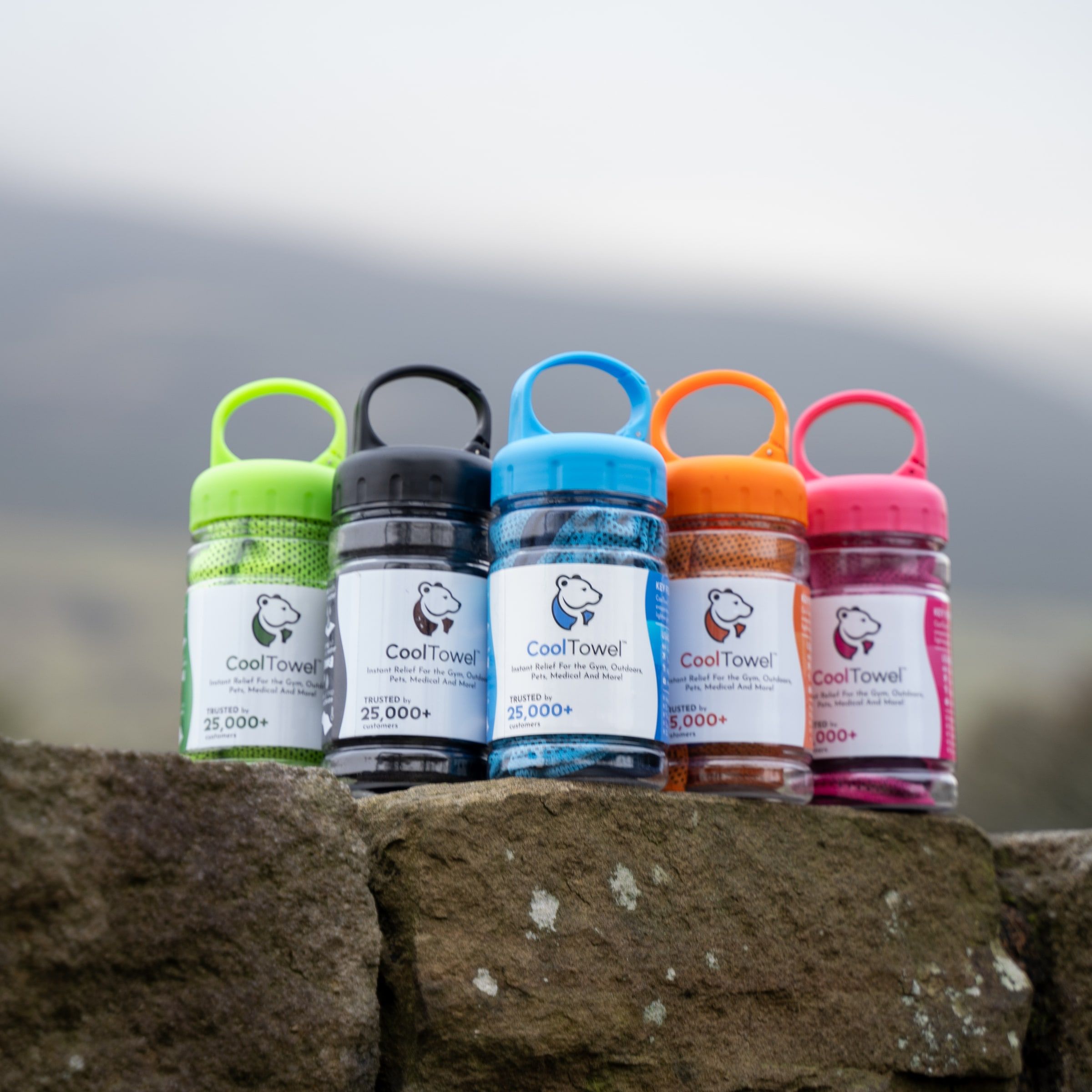 Five CoolTowel bottles in a row, one of each colour