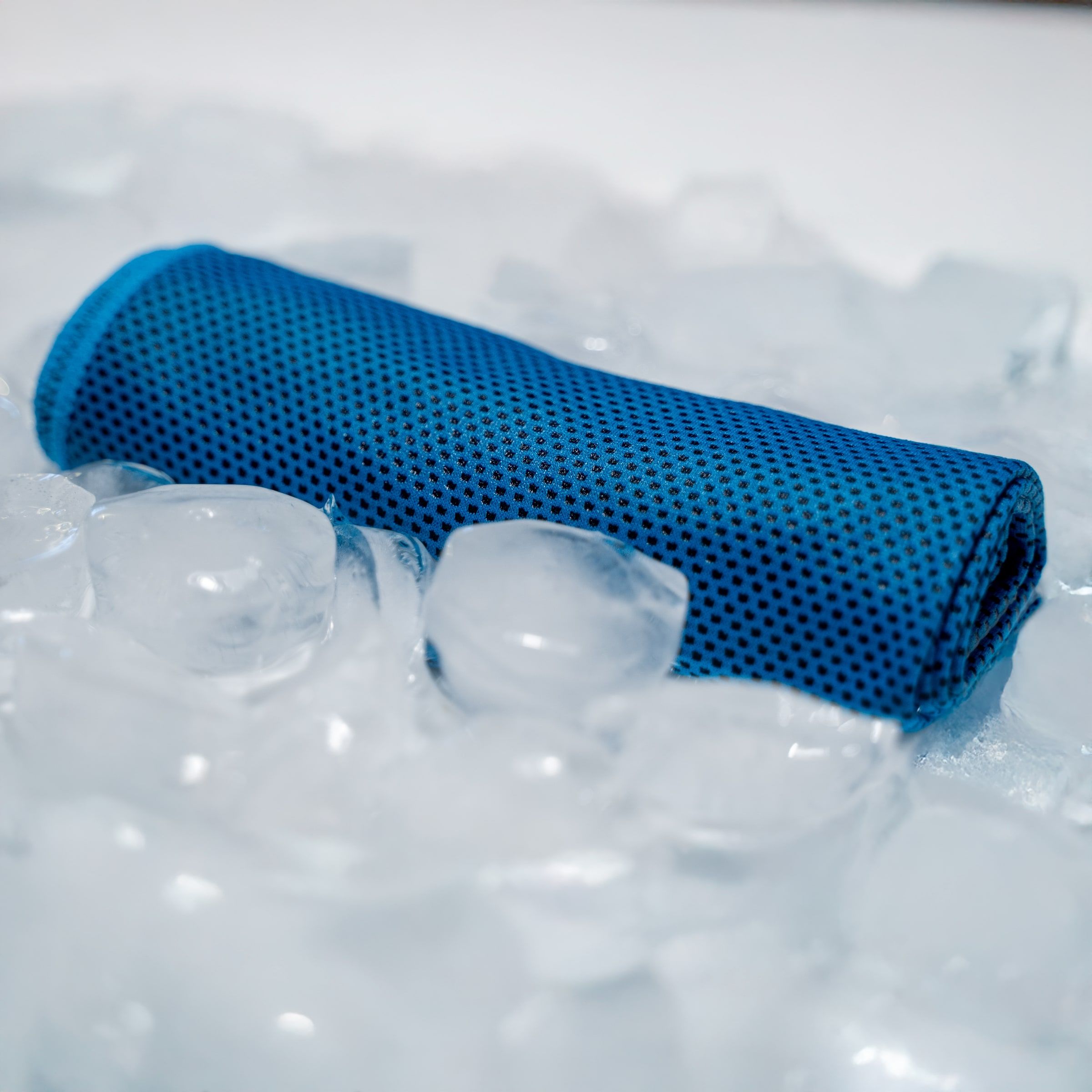 A blue CoolTowel laid across ice cubes