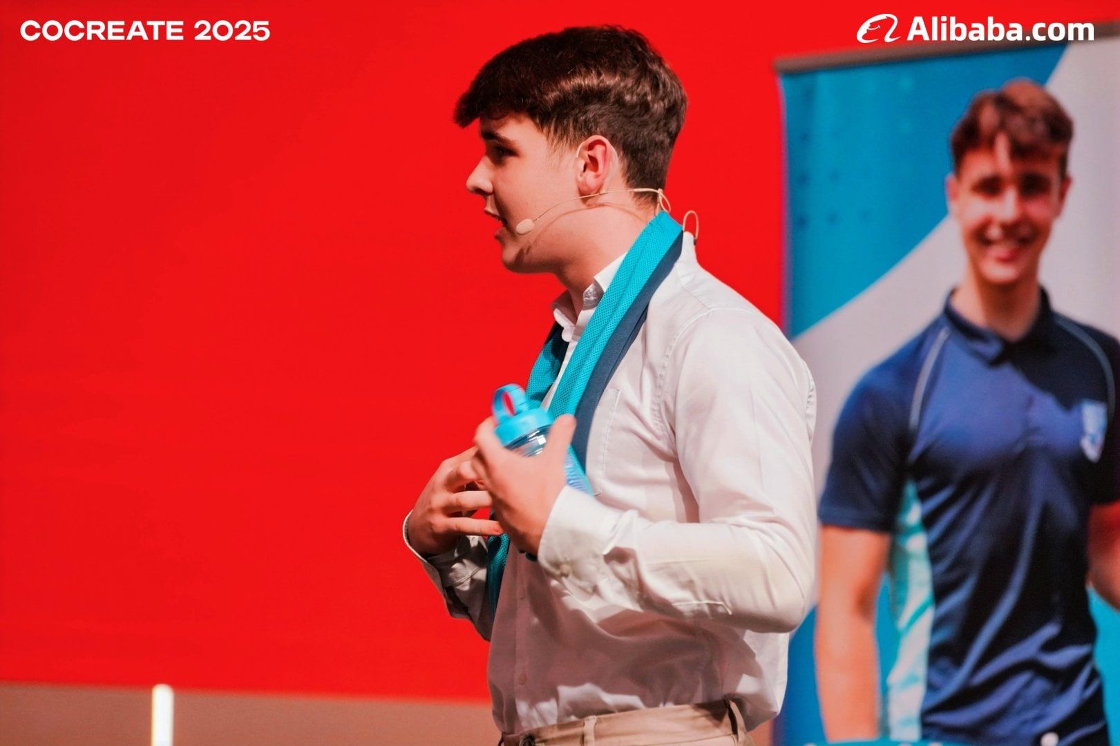 Harrison Nott on stage at CoCreate with the soaked CoolTowel round his neck
